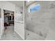 Shower with glass door, marble-look tiles, window, and access to walk-in closet at 3109 Hugh Bennett Dr, Johns Island, SC 29455