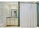 Bathroom with floral wallpaper, a white shower curtain and light colored vanity at 312 President St, Charleston, SC 29403