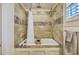 A tiled tub and shower combination features a white curtain and showerhead at 312 President St, Charleston, SC 29403