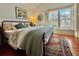 Cozy bedroom featuring hardwood floors, large window, comfortable bed, and a colorful rug at 312 President St, Charleston, SC 29403