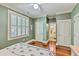 Olive green bedroom features wood flooring, white trim and doors and a view into the bath at 312 President St, Charleston, SC 29403