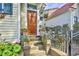 Inviting front entry with wooden door, potted plants, and steps, surrounded by a black metal fence at 312 President St, Charleston, SC 29403