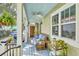 Cozy porch with blue ceiling, wicker furniture, hanging plants, and view of the neighborhood at 312 President St, Charleston, SC 29403