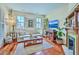 Sunlit living room featuring hardwood floors, fireplace, comfortable seating, and bright windows at 312 President St, Charleston, SC 29403