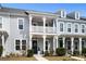 Charming townhouse with a second-story porch, and black front door with nice landscaping at 3125 Sturbridge Rd, Mount Pleasant, SC 29466