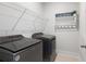 Modern laundry room with updated washer and dryer units, plus practical storage shelving at 3125 Sturbridge Rd, Mount Pleasant, SC 29466