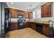 Kitchen with dark wood cabinets, granite countertops, and black appliances at 324 Saucer Rd, Summerville, SC 29486