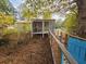 Backyard view featuring a screened-in porch, wooden ramp access, and views of the surrounding foliage at 3695 Cannon Rd, Round O, SC 29474