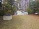 Charming exterior view of a light green home surrounded by trees and a sprawling lawn covered in fallen leaves at 3695 Cannon Rd, Round O, SC 29474