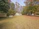 Quaint cottage-style home featuring a lush front lawn with mature trees and a welcoming entrance, perfect for outdoor enjoyment at 3695 Cannon Rd, Round O, SC 29474