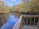 Wooden deck overlooking a tranquil river with lush trees on the opposite bank, offering a beautiful view at 3695 Cannon Rd, Round O, SC 29474