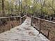 Wooden walkway with railings surrounded by trees and greenery, providing a nature trail experience at 3695 Cannon Rd, Round O, SC 29474