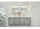 A bathroom featuring double sink vanity with granite countertops, modern fixtures, and a view of a marble shower at 4045 Oxeye Loop, Johns Island, SC 29455