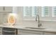 Kitchen sink area features stainless faucet, white cabinets, subway tile backsplash and light from window at 4045 Oxeye Loop, Johns Island, SC 29455