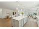Open concept kitchen with island, seating, stainless appliances, and hardwood floors flows to dining and living at 4045 Oxeye Loop, Johns Island, SC 29455