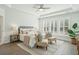 Serene main bedroom with tray ceilings, plantation shutters, and a seating area at 4045 Oxeye Loop, Johns Island, SC 29455