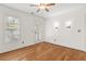 A sunlit bedroom featuring hardwood floors, a ceiling fan, neutral walls, and a glass door at 405 Springfield Rd, Mount Pleasant, SC 29464