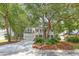 Classic two-story white home with a double porch and black shutters nestled among mature trees at 405 Springfield Rd, Mount Pleasant, SC 29464