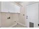Functional laundry room with overhead cabinets, tile floors, and access door at 405 Springfield Rd, Mount Pleasant, SC 29464