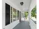 Charming outdoor porch featuring gray flooring, white railings, black shutters, and a ceiling light fixture at 405 Springfield Rd, Mount Pleasant, SC 29464