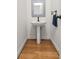 Cozy powder room featuring a pedestal sink, hardwood floors, and stylish mirror at 405 Springfield Rd, Mount Pleasant, SC 29464