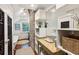 Bright bathroom with a clawfoot tub, custom vanity, brick accent wall, and a view to the outside at 41 Tradd St, Charleston, SC 29401