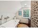 Bright bathroom featuring a clawfoot tub, toilet, vessel sink, and large window with natural light at 41 Tradd St, Charleston, SC 29401