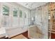 Bathroom featuring a glass shower with brick-style tiling, large windows with shutters, and hardwood floors at 41 Tradd St, Charleston, SC 29401