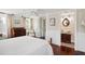 Bright bedroom with hardwood floors, a classic dresser, and a view into a traditionally styled bathroom at 41 Tradd St, Charleston, SC 29401