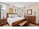 Bright and airy bedroom featuring a rustic wood bed frame, hardwood floors, and ample natural light at 41 Tradd St, Charleston, SC 29401