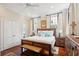 Bright bedroom featuring a rustic wood bed frame, hardwood floors, two windows with shutters and a ceiling fan at 41 Tradd St, Charleston, SC 29401