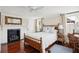 Charming bedroom featuring a cozy fireplace, hardwood floors, and a comfortable wooden bed frame at 41 Tradd St, Charleston, SC 29401