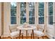 Bright breakfast nook featuring a marble table, views to the garden and brick accent wall at 41 Tradd St, Charleston, SC 29401