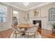 Dining room with hardwood floors, a round table, and a fireplace, bathed in natural light at 41 Tradd St, Charleston, SC 29401