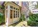 Grand entrance featuring multi-paned glass doors, surrounded by lush greenery and classic brick architecture at 41 Tradd St, Charleston, SC 29401