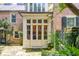 Elegant entrance with multi-paned glass doors, surrounded by lush greenery and classic brick architecture at 41 Tradd St, Charleston, SC 29401
