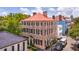 Elegant brick home with red tile roof, symmetrical windows, and mature trees lining the street at 41 Tradd St, Charleston, SC 29401