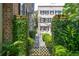 Ornate wrought iron gate surrounded by lush, climbing greenery leads to a secluded garden at 41 Tradd St, Charleston, SC 29401