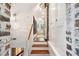 Hallway with wooden staircase, white walls, brick accents, and linen closets on the first floor at 41 Tradd St, Charleston, SC 29401