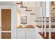 Hallway with a sink, white paneled walls and access to the upper floors via the wooden staircase at 41 Tradd St, Charleston, SC 29401