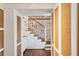 Hallway with a staircase, paneled walls, exposed brick and built-in cabinets with rattan inserts at 41 Tradd St, Charleston, SC 29401
