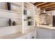 Bright kitchen featuring open shelving, brick backsplash, and stainless steel range hood at 41 Tradd St, Charleston, SC 29401