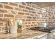 Granite countertop in the kitchen, accented by brick backsplash and chef's tools and cookbooks at 41 Tradd St, Charleston, SC 29401
