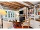 Cozy living room with exposed beams, fireplace, and French doors leading outside at 41 Tradd St, Charleston, SC 29401