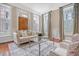 Elegant living room with lots of natural light, hardwood floors, comfortable seating and area rug at 41 Tradd St, Charleston, SC 29401