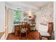 Bright home office with hardwood floors, large window, exposed brick accent wall and modern shelving at 41 Tradd St, Charleston, SC 29401
