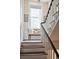 Elegant stairway with white railings, wooden steps, and a cozy bench under a window at 41 Tradd St, Charleston, SC 29401