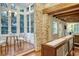 Sunroom with brick accents, table and chairs, and large windows with views of the outdoors at 41 Tradd St, Charleston, SC 29401