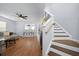 Open-concept living room featuring hardwood floors, a ceiling fan, and a staircase leading to the upper level at 521 Holiday Dr, Summerville, SC 29483