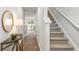 Hallway with stairs, table with mirror, and a view of the sunny living room at 539 Golden Embers Way, Summerville, SC 29486